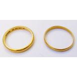 A 22ct. gold wedding band - sold with another - marks worn