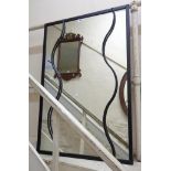 Justin Steel: an ebonised metal framed oblong wall mirror with applied wrought decoration