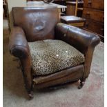 A late Victorian studded brown leather upholstered armchair, set on turned front legs with brown