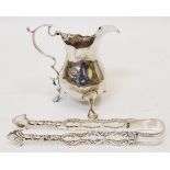 A pair of ornate antique pierced silver sugar tongs - sold with a Georgian cream jug - marks worn