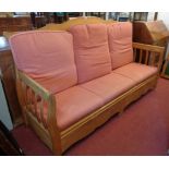 A 6' 4" 20th Century waxed oak slat back settee with loose cushion seat and back, with two blind