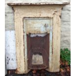 A painted cast iron fireplace insert with scroll and beaded decoration