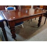An early 19th Century mahogany extending dining table with two leaves and winder, set on tulip