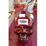 A red glass skull shaped bottle