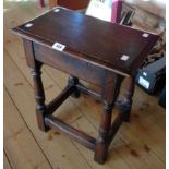 An 18" antique stained oak joint stool set on turned supports and open stretcher base