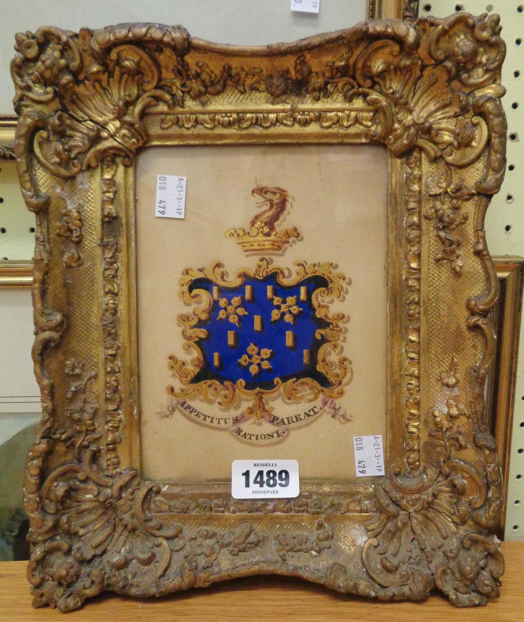 An antique ornate gilt gesso framed heraldic emblem painted in watercolours with gilding - 7 1/2"