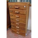 A 20" mid 20th Century oak office chest with flight of eight long drawers