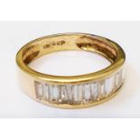 A marked 14k yellow metal ring, set with paved row of baguette diamonds