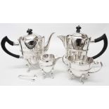 A silver four piece tea set with petal shaped tops, swept paw feet and associated sugar nips, the