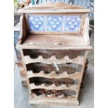 A stripped pine sixteen bottle wine rack with tile set raised back and shelf -a/f