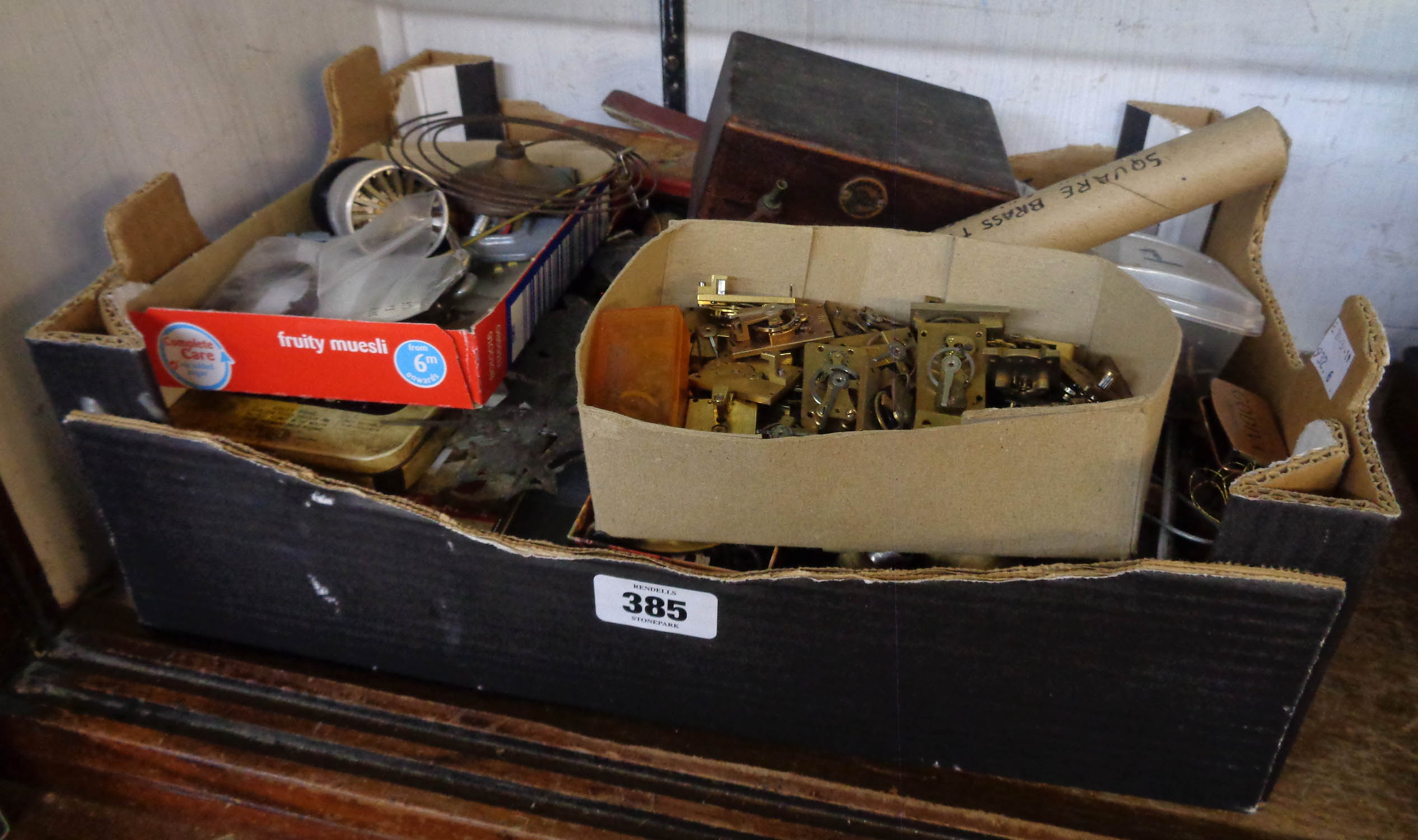 A box containing clock makers spares, escapements and tools, etc.