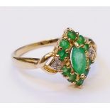 An imported 375 gold Edwardian style ring, set with marquise and other small emeralds flanked by