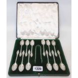 A cased set of twelve ornate teaspoons and sugar tongs with cast terminals by Mappin & Webb - London