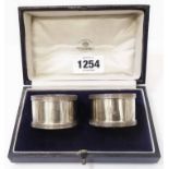 A cased pair of Mappin & Webb silver napkin rings with cast rims and engraved initial 'A'