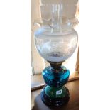 A table oil lamp with turquoise glass reservoir and etched glass shade
