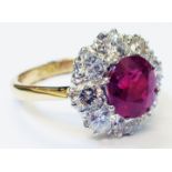 A marked 18ct. yellow metal ring, set with central circular 2.75ct. ruby within a diamond