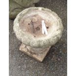 A small cast concrete garden pedestal urn