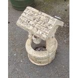 A small concrete garden wishing well