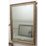 A decorative gilt framed bevelled oblong wall mirror