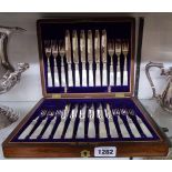 A mahogany canteen containing a set of twelve each silver plated fruit knives and forks with