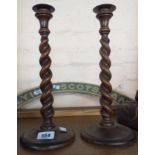 A pair of oak barley twist candlesticks