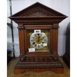 A late 19th Century German stained oak cased mantel clock of architectural design with brass and