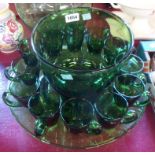 A green glass punch bowl and twelve glasses - sold with a similar green glass dish