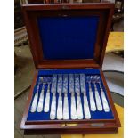 A mahogany canteen containing a set of twelve each silver plated dessert knives and forks with