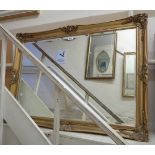 An ornate gilt gesso style framed bevelled oblong wall mirror - 3' 5" wide