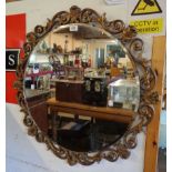 A vintage Aisonea gilt framed bevelled circular wall mirror with pierced scroll border