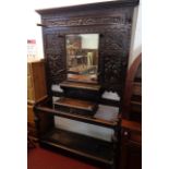 A 4' 4" Victorian ornate carved and stained oak hallstand with various motifs, pegs, bevelled mirror