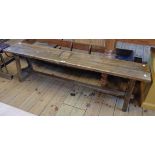 A 5' 3" old oak form bench with pegged stretcher