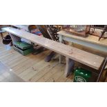 A 9' 6" old painted pine form bench, set on shaped standard ends