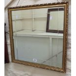 A gilt framed square wall mirror with cut border to plate