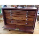 A Union watchmaker's chest of five long graduated drawers enclosed by a pull-out fall-front - with