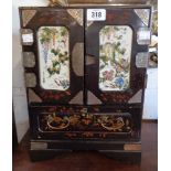 An 11 1/4" late 19th/early 20th Century Chinese lacquered cabinet with enamelled ceramic door