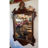 A Georgian style stained wood and parcel gilt framed fret cut oblong wall mirror with shell motif to