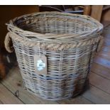 A 21" diameter wicker log basket with rope handles