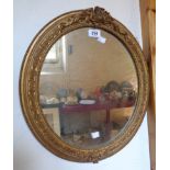 An old ornate gilt gesso framed oval wall mirror