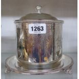 A late Victorian silver plated flip-top biscuit barrel with engraved decoration and tray base