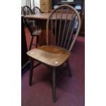 A set of four 20th Century polished mixed wood hoop stick back kitchen chairs, set on simple