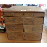 A 13 1/2" old stained pine collector's chest with an array of six drawers