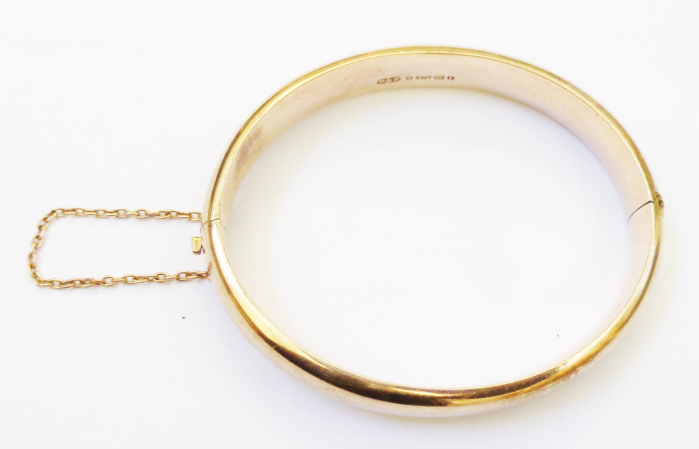 A 9ct. gold clasp bangle with safety chain - Birmingham