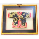 A box framed Chinese doll's jacket with ornate embroidered decoration