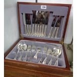 A polished wood canteen containing a six place setting of silver plated cutlery with beaded