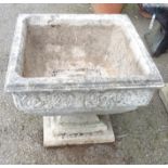 A cast concrete square garden pedestal planter