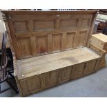 A 6' antique pine settle with fielded panelled back, flanking open arm rests, twin plank seat and