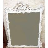 An ornate later painted carved wood framed wall mirror with Rococo style pierced pediment and