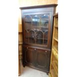 A 3' 10" antique stained oak two part corner cabinet with moulded cornice and scalloped shelves