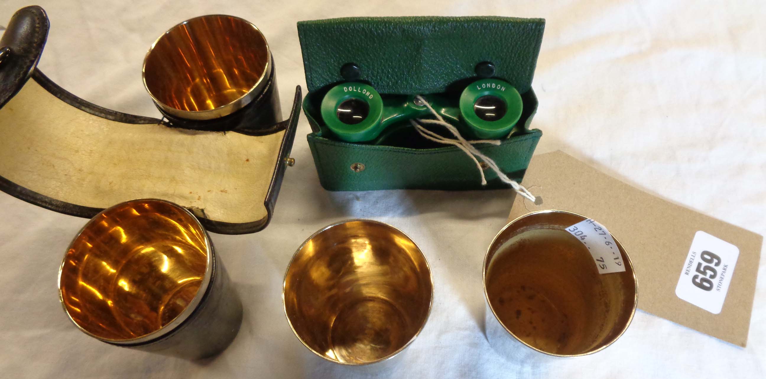 A set of four silver plated hunting cups in leather case - sold with a pair of Dollond opera